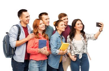 education, high school and technology concept - group of smiling students with books taking selfie by smartphone over white background