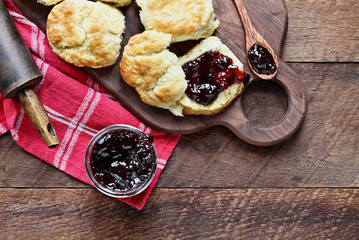 Buttermilk southern biscuits or scones served with homemade fruit preserves. Top view.