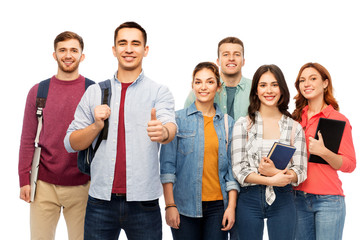 education, high school and people concept - group of smiling students with books showing thumbs up over white background