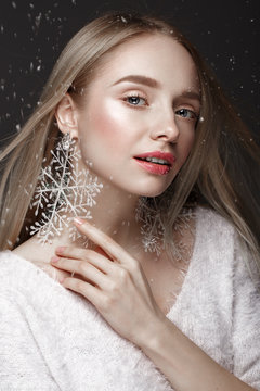 Beautiful blonde girl in a winter image with snow. Beauty face.