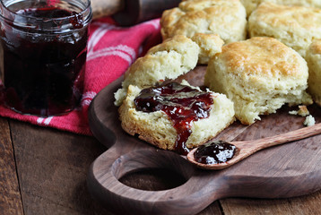 Buttermilk southern biscuits or scones served with homemade fruit preserves. Top view.
