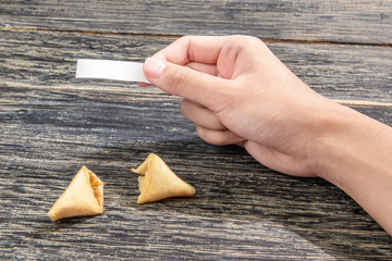 Human hand holding blank paper for quote or message from fortune cookies