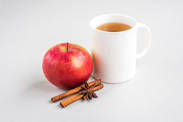 Mug of hot tea with apple and cinnamon on gray background. Season flu. Disease.