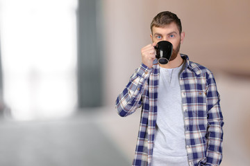 Young man holding warm cup of tea/coffee