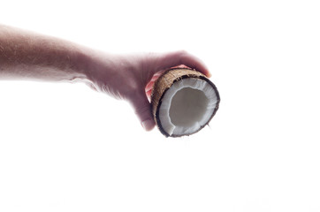 Concept of pouring coconut milk from fresh tasty coconut in male hand against whiet background