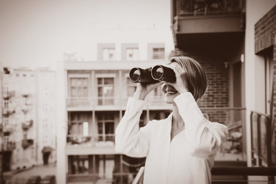 Beatiful Girl With Binocular Looking For Something With House On Background.