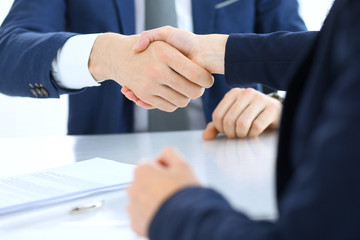 Obraz premium Group of business people or lawyers shaking hands finishing up a meeting , close-up. Success at negotiation and handshake concepts