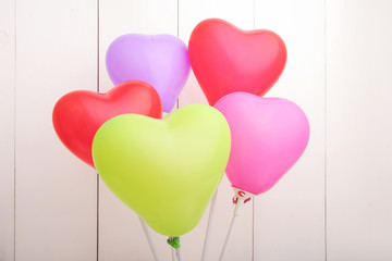 Fototapeta na wymiar Colorful heart ballons against white wall