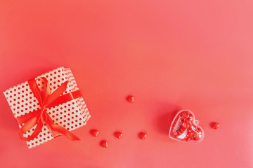 Valentines day background with red candy hearts and a gift in box, top view