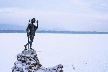 "Old lake" in Tata, Hungary with the statue of Saint John in winter