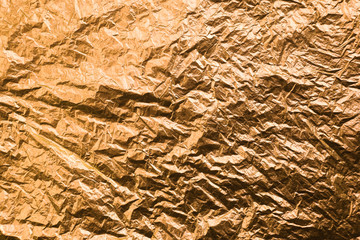 Crumpled yellow colored paper. Gold textured background.