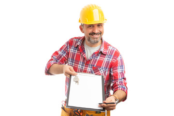 Builder pointing with pen on clipboard holding house keys.