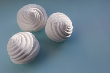 White marshmallows on blue background. Flat lay, copy space