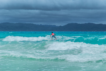 Surfer on turquoise azure Ocean Wave in Siargao, Philippines