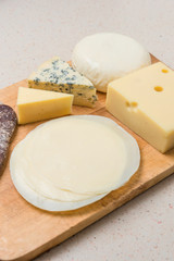 Different cheeses served on wooding cutting board