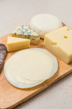 Different cheeses served on wooding cutting board