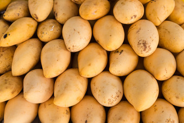 Mangoes pile put together have pattern in front of shop at market