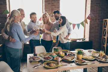 Close up of gathered relatives in decorated house dinner table w © deagreez