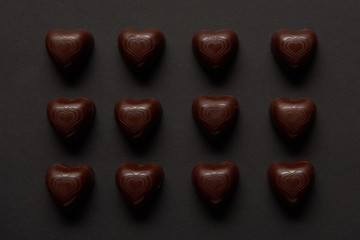 top view of sweet chocolate hearts on black background