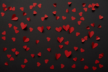 seamless black background with copy space and paper cut red hearts
