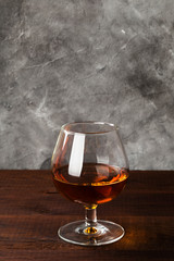 Cognac in glass on wooden background