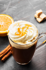 Autumn drink of coffee with orange juice and cream on dark background