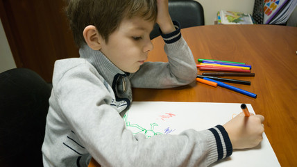 child draws with colored markers