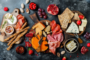 Obraz na płótnie Canvas Appetizers table with italian antipasti snacks. Brushetta or authentic traditional spanish tapas set, cheese and meat variety board over black stone background. Top view, flat lay