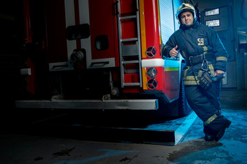 Fototapeta na wymiar Full-length photo of man firefighter at fire truck