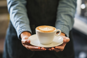 Latte art coffee in hands