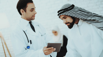 Male Doctor Consulting Arabic Man at Hospital
