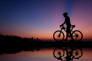 Obraz premium Silhouette of cyclist with mountain bike on beautiful sunset time.