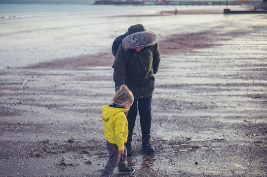 Toddler and grandmother on the beach in winter