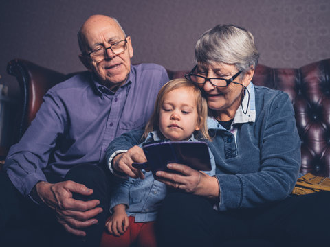 Grandparents and toddler looking at smartphone