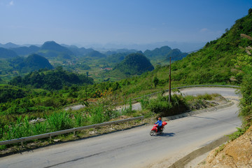 Ha Giang / Vietnam - 01/11/2017: Motorbiking backpackers on winding roads through valleys and karst mountain scenery in the North Vietnamese region of Ha Giang / Dong Van.