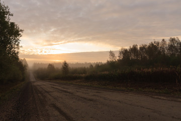Naklejka na ściany i meble Long gravel road in countryside at morning landscape