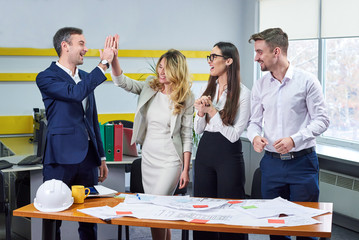 Team of young business people discussing blueprin