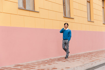 Smiling young asian business man talking on mobile phone