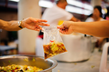 The nomadic hand received food donations from the hands of volunteers: the concept of sharing the giving