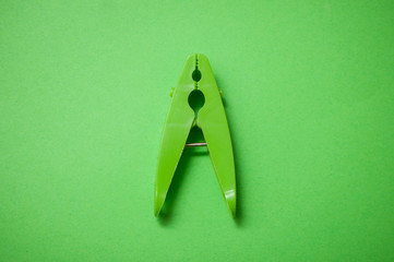 closeup of green plastic clothespin on green background