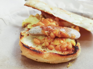 Grilled toasts served with beans, scrumbled eggs and sausage for an English breakfast.