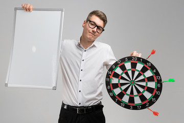 young man in glasses with target with dart not in center and empty plate in his hands isolated on...