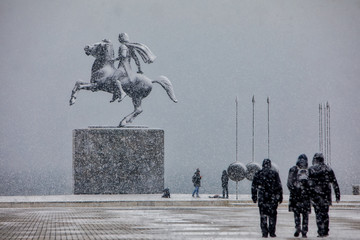 people walking in the snow in the center of the city on a winter day