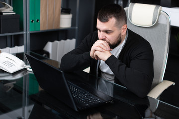Portrait of young man sitting at table in office