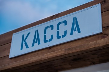 A sign of the ticket office in Russia. Purchase tickets for entertainment. Inscription in Russia means Cash Desk. Blue letters on wooden background.