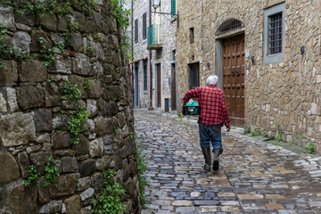 Fototapeta na wymiar old man walking on the street, rural village
