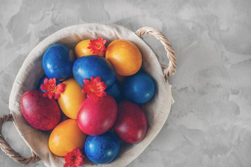 Colorful easter eggs lying in a basket on a beautiful vintage background. View from above. Easter Brunch Copy space