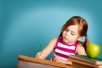 Little Girl Writing While in School Desk
