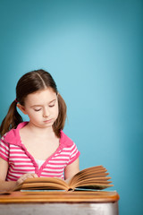 Girl Reading a Book While Sitting in School Desk - Room for Text