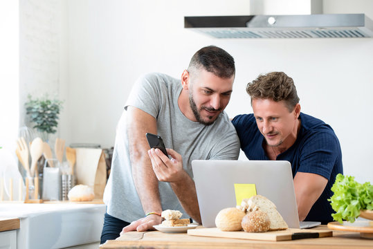 Male caucasian gay couple using laptop computer at home